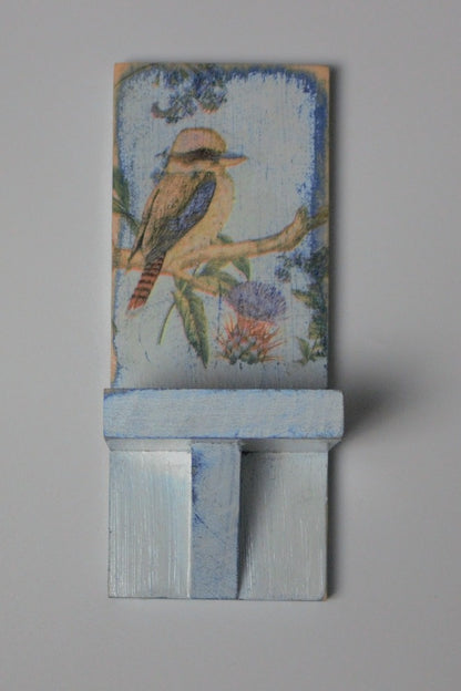 distressed blue and white wooden wall mounted candle or ornament  shelf decorated with vintage style kookaburra sitting on a branch with red and blue flowers