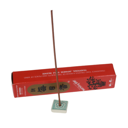 red  and gold box of myrrh morning star incense behind an incense tile holding a japanese incense stick