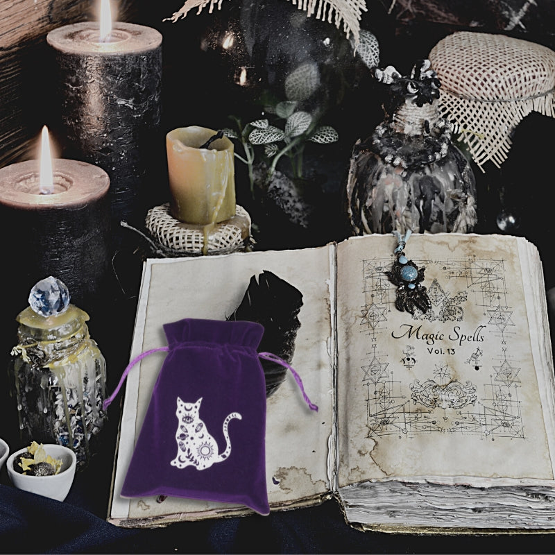 purple tarot bag on an open magic spell book surrounded by candles 